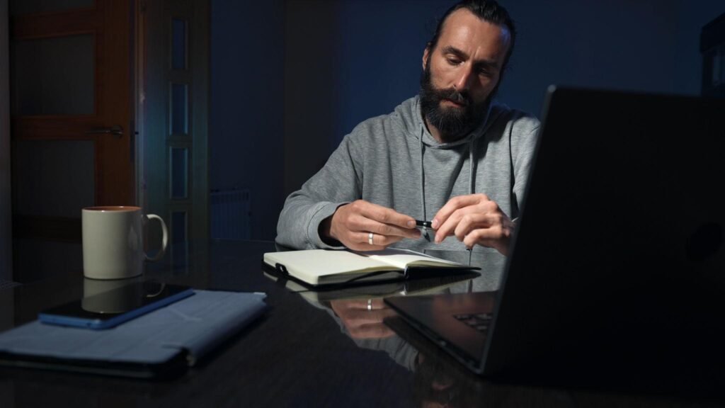 Focused Adult Man Journaling at Home in a Dimly Lit Setting